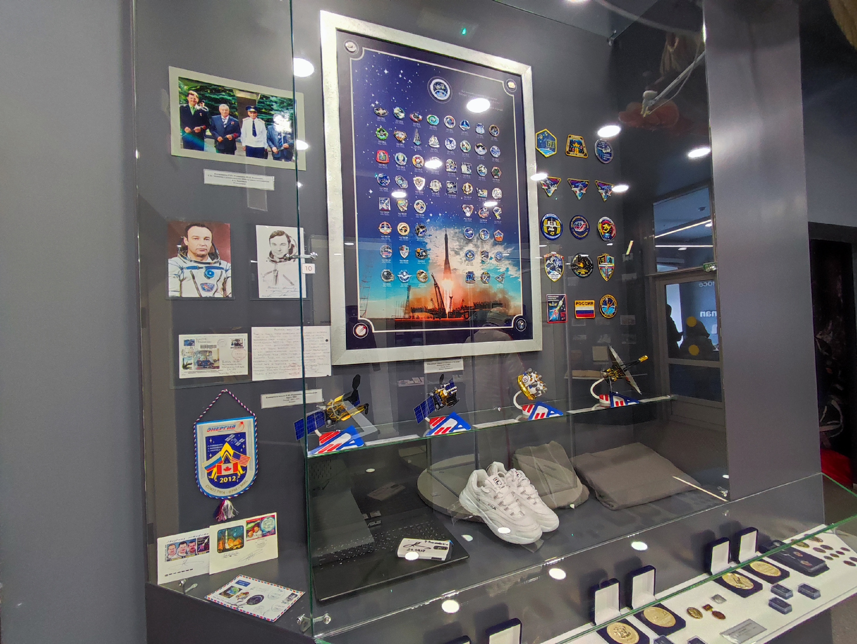 Стенд со значкам миссий на международных космических станциях в Доме-музее имени Юрия и Валентины Гагариных (Оренбург)