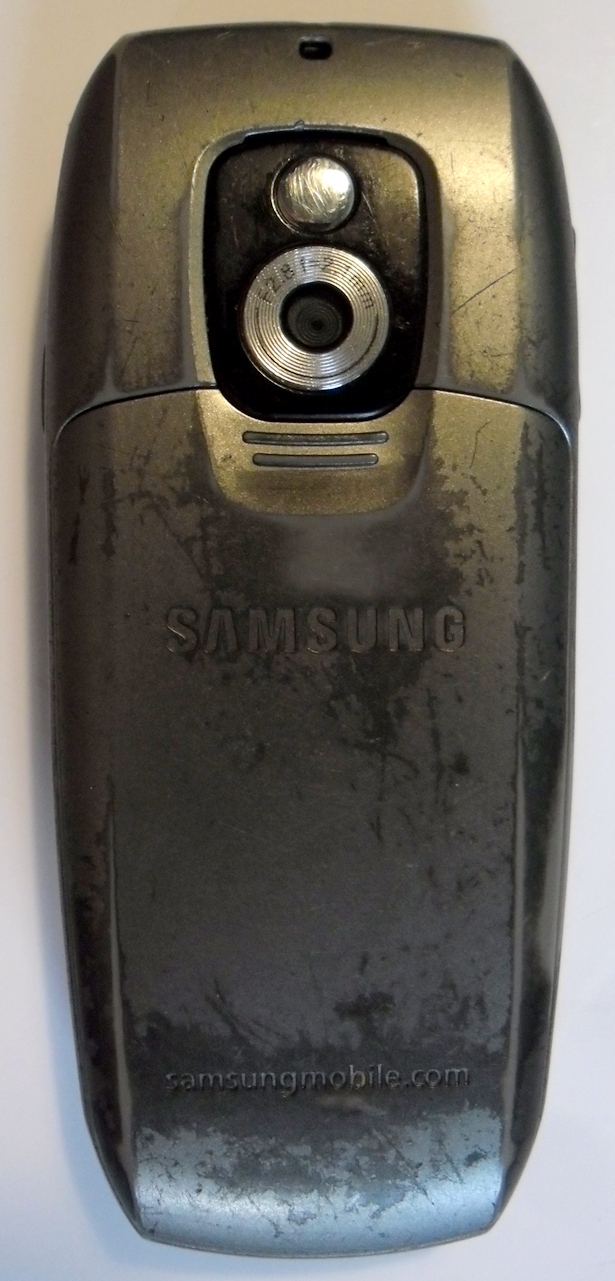 Вид со стороны камеры. Над ней есть небольшое выпуклое зеркальце для селфи и видеосвязи. Состояние телефона — после долгих лет использования.